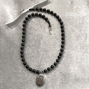 A black & silver tone crafted necklace.